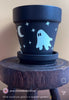 From the dark of night, the moon appears and casts a haunted glow. Perfect for a haunted garden, this black planter is made complete with 4 cute spooky ghosts, stars and a crescent moon to enhance your decor. 