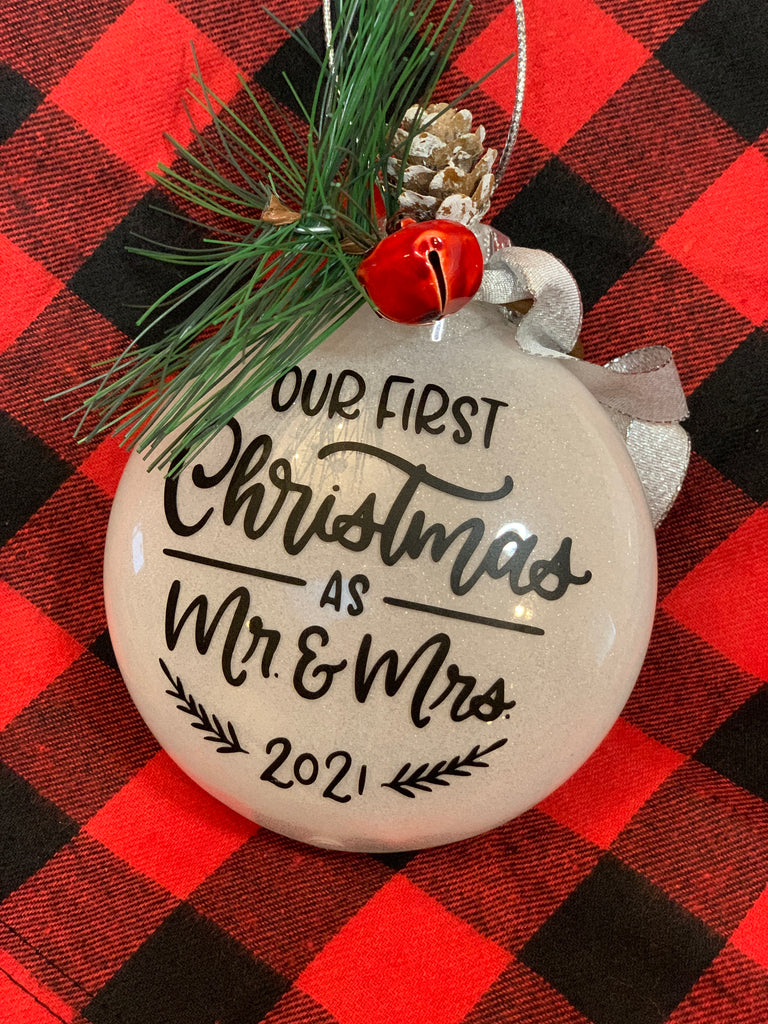 Our First Christmas as Mr. & Mrs. 2021 White Glitter ornament with black lettering and greenery adornments for a keepsake ornament!