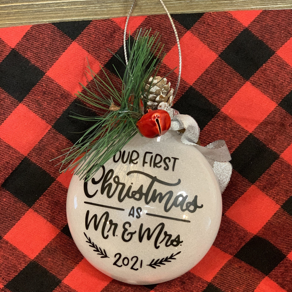 Our First Christmas as Mr. & Mrs. 2021 White Glitter ornament with black lettering and greenery adornments for a keepsake ornament!