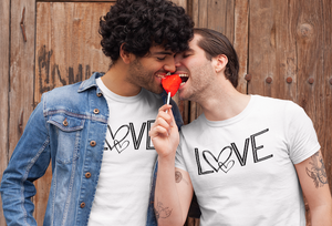 The word Love in an outline capitalized font with a double heart where the O goes across the chest. Featured in black on various color shirts. 